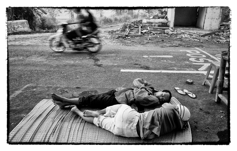Men sleep on the street following an earthquake in Indonesia