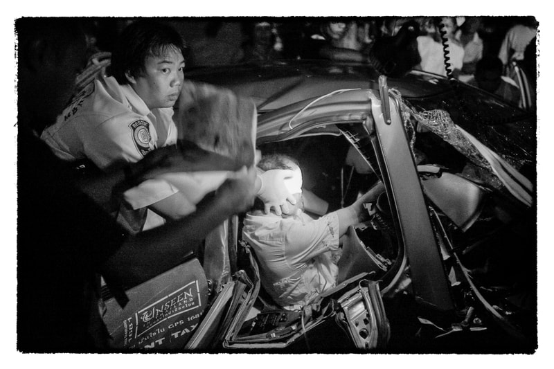 Bangkok paramedics work to free an accident victim
