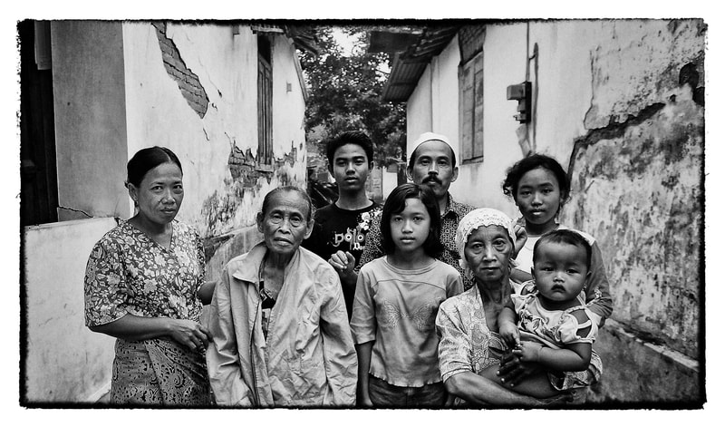 An Indonesia family Indonesians gather outside their earthquake damaged home